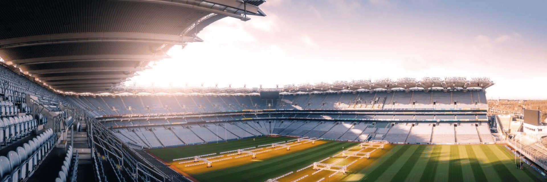 Bon Jovi Dublin 2026 – panoramic view of Croke Park stadium with empty tiered seating and a green pitch under soft sunlight.