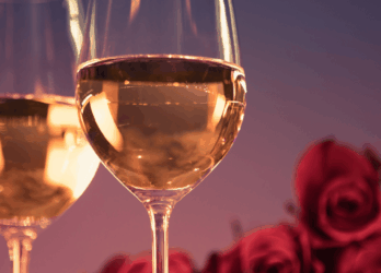 Two glasses of white wine on a romantic table setting with red roses at The Grafton Hotel in Dublin. Valentine's Day in Dublin