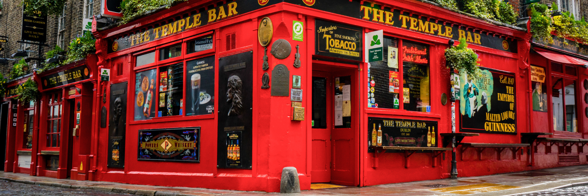 Iconic red exterior of The Temple Bar pub in Dublin’s cultural quarter, a popular sightseeing stop for travelers on a vacation to Dublin while staying at The Grafton Hotel.